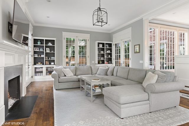 a dining room with furniture a chandelier and wooden floor