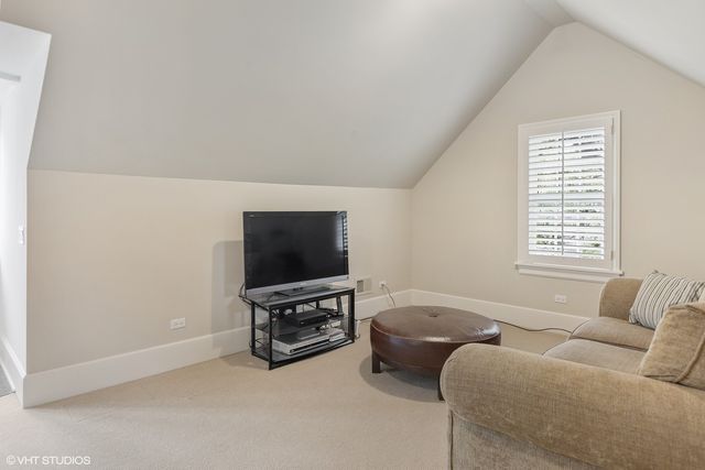 a front view of a house with a yard and fountain in middle of the green field