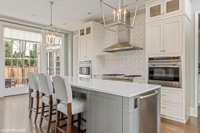 a view of a patio with couches table and chairs under an umbrella with a fire pit