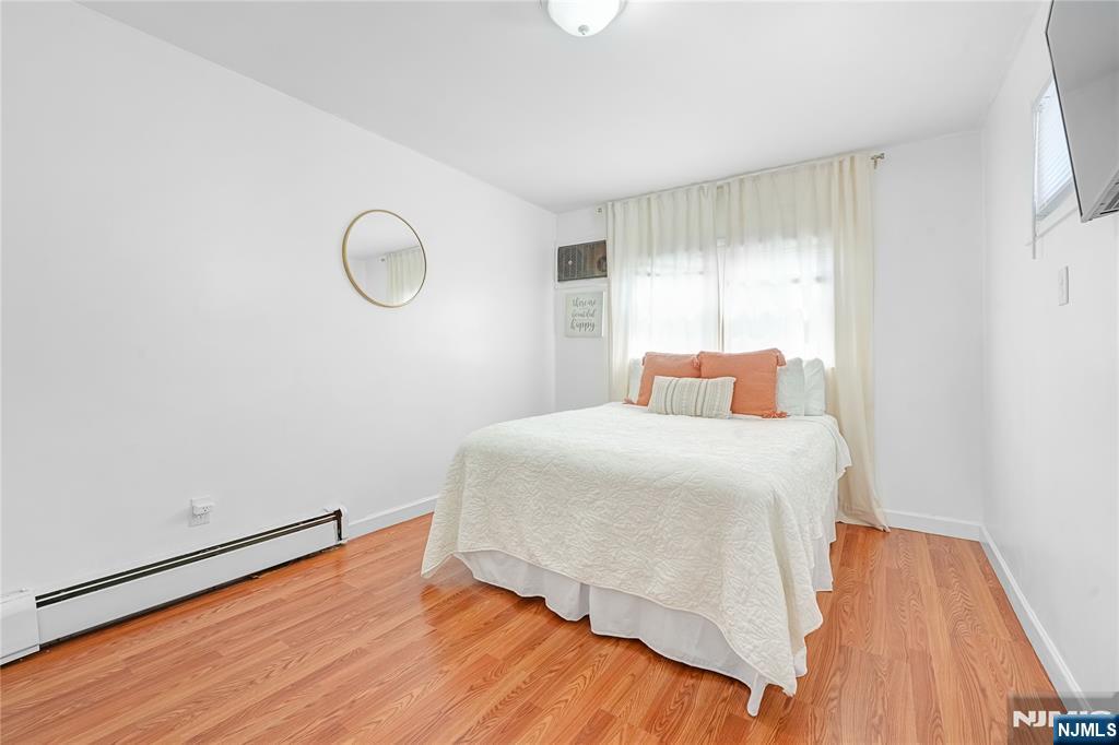 728 Devon Street Kearny, NJ 07032 - Photo 12 of 26 a bedroom with a bed and wooden floor