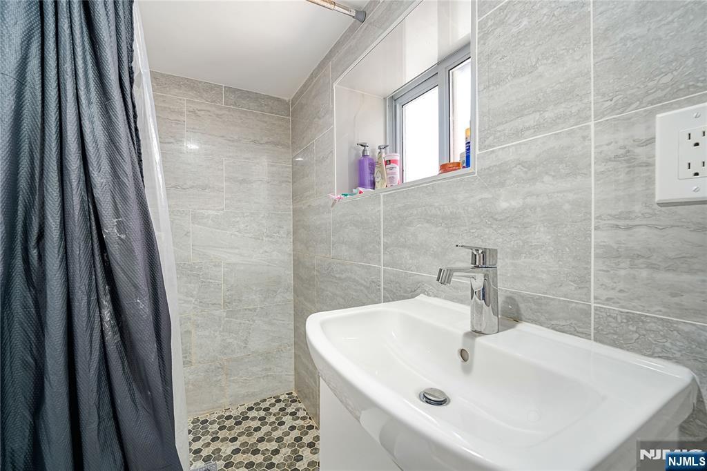 728 Devon Street Kearny, NJ 07032 - Photo 23 of 26 a bathroom with a sink a window and shower