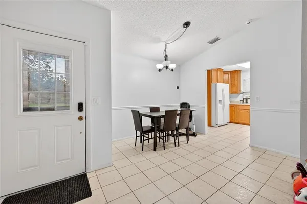 a view of a dining room with furniture a chandelier and wooden floor