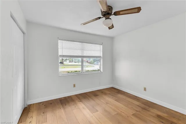 a view of a room with wooden floor and a ceiling fan