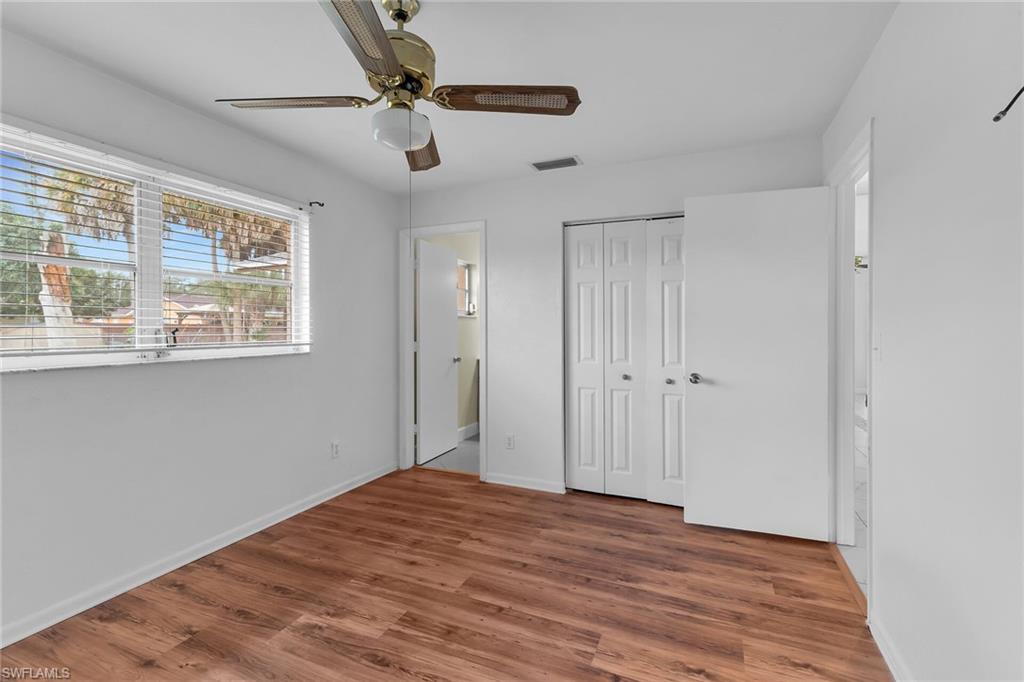 4502 22nd Place Southwest Naples, FL 34116 - Photo 20 of 30 Unfurnished bedroom featuring wood finished floors, ceiling fan, and a closet