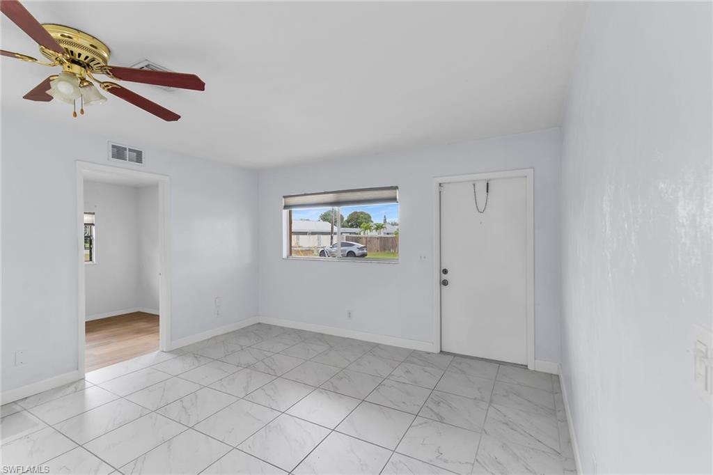 4502 22nd Place Southwest Naples, FL 34116 - Photo 2 of 30 Empty room featuring light marble finish floors and ceiling fan