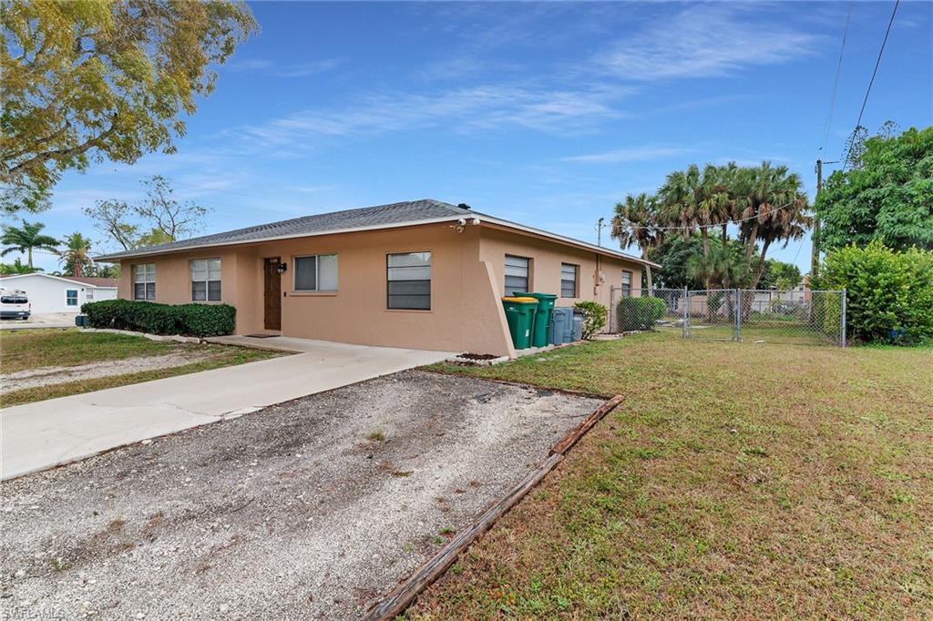 4502 22nd Place Southwest Naples, FL 34116 - Photo 27 of 30 View of property exterior with stucco siding, a gate, and driveway