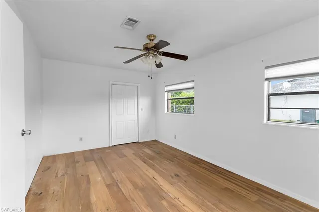 an empty room with a window and a ceiling fan