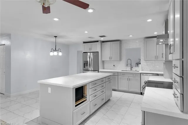 a kitchen with white cabinets appliances and sink