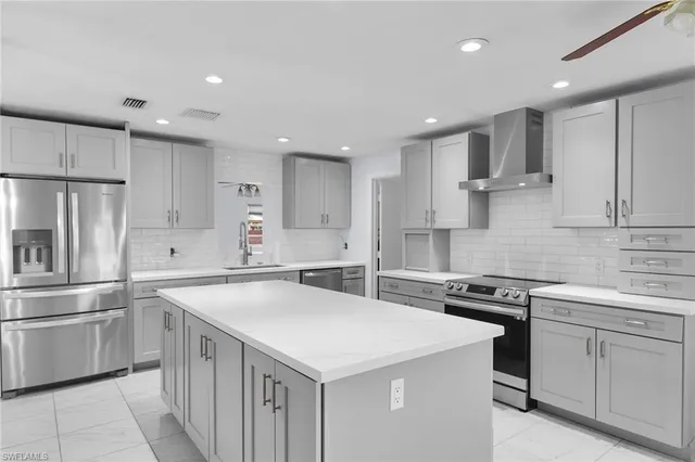a kitchen with a sink a stove a refrigerator and white cabinets