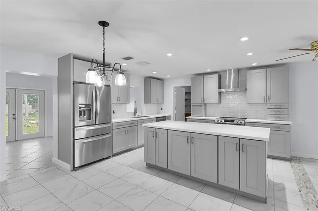 a kitchen with stainless steel appliances granite countertop a sink a stove and a refrigerator