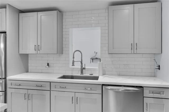 a kitchen with white cabinets and a sink