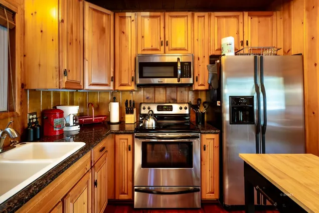 a kitchen with stainless steel appliances a stove refrigerator sink and microwave