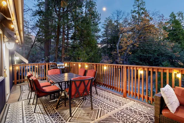 a balcony with wooden floor and outdoor seating