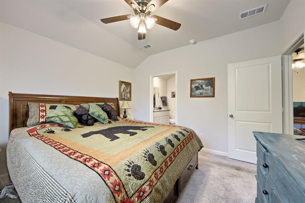 420 Jameson Springtown, TX 76082 - Photo 13 of 29 a bedroom with a large bed and a chandelier