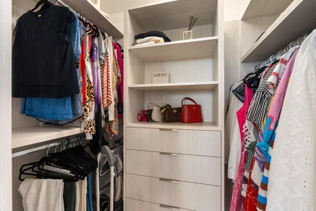 a view of walk in closet with clothes and shoes