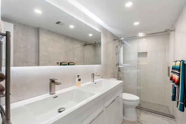 a bathroom with a sink a toilet and shower