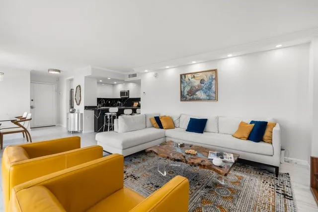a living room with furniture kitchen view and a table