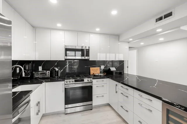 a kitchen with a sink stove top oven and cabinets