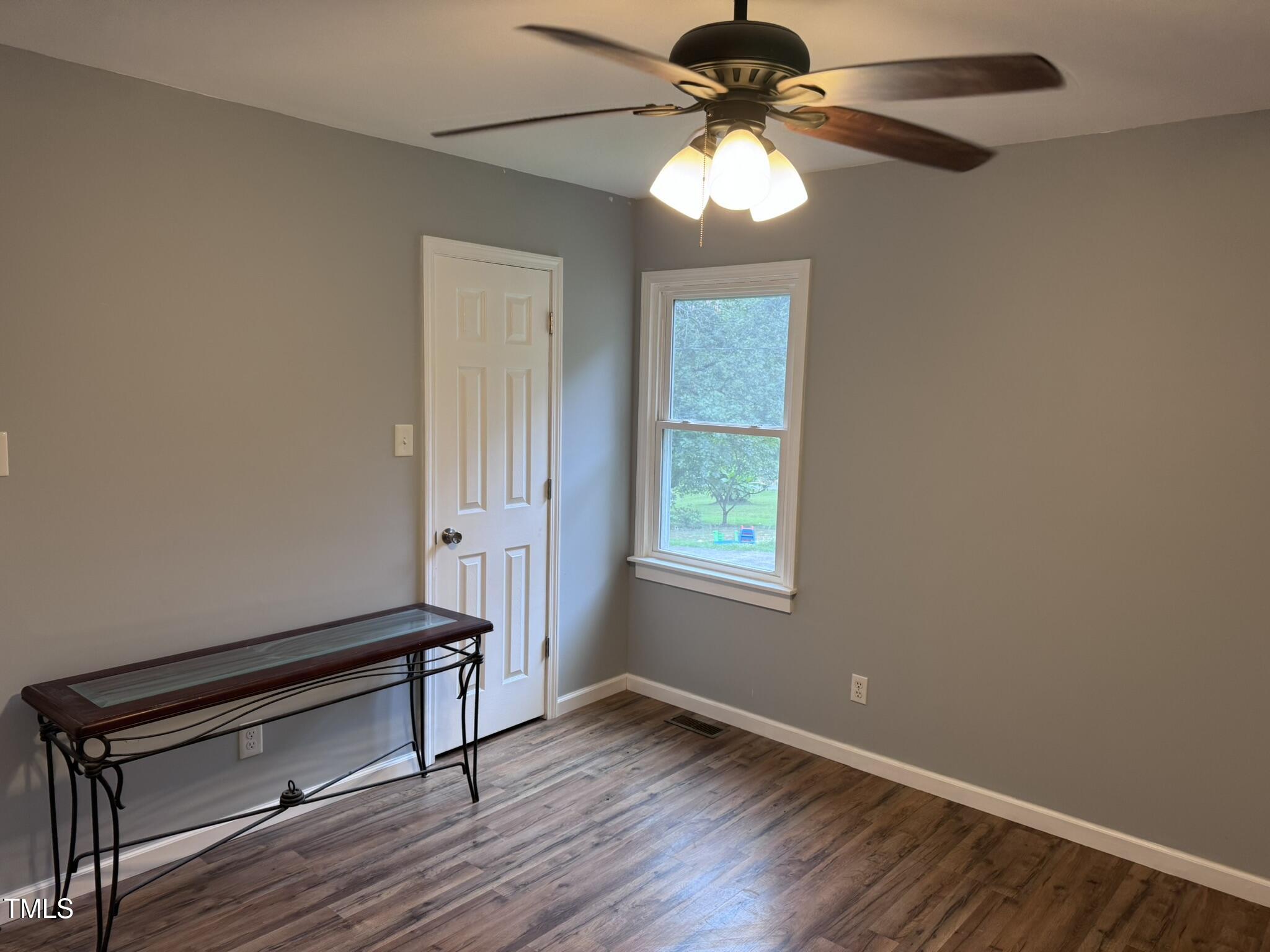 6740 Guess Road Hillsborough, NC 27278 - Photo 15 of 17 an empty room with wooden floor fan and windows