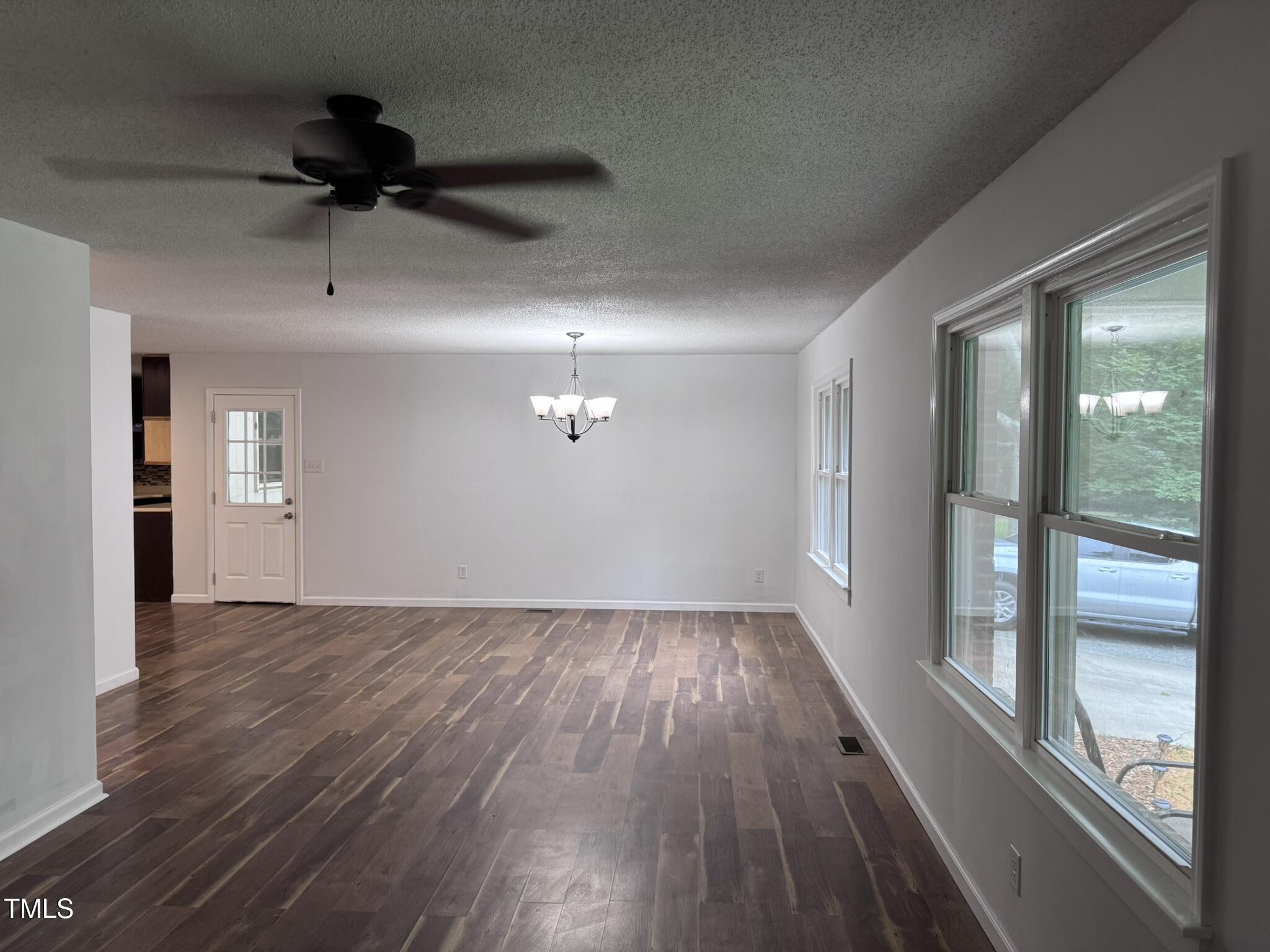 6740 Guess Road Hillsborough, NC 27278 - Photo 5 of 17 an empty room with wooden floor fan and windows