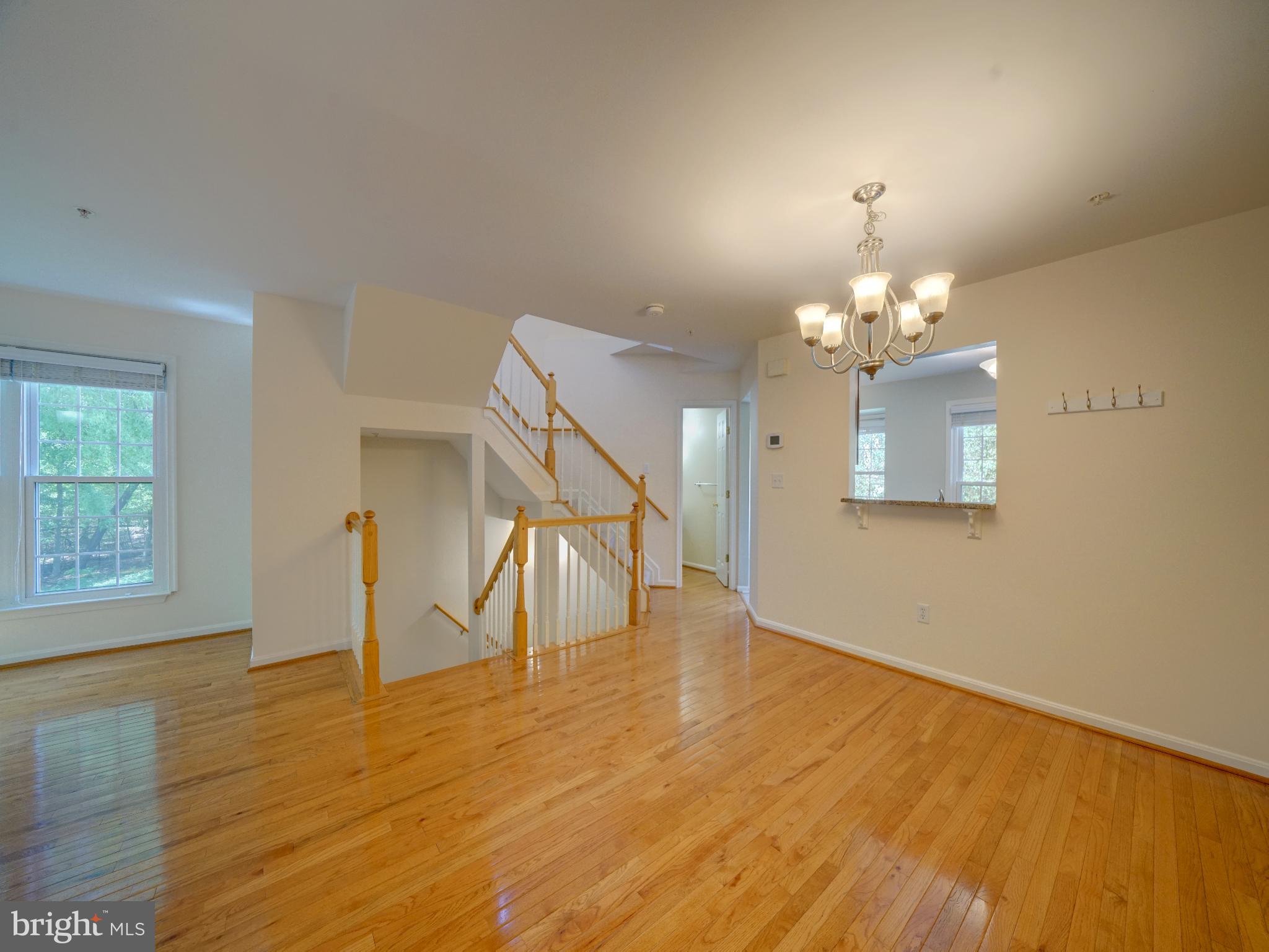 2238 Commissary Circle Odenton, MD 21113 - Photo 12 of 48 a view of a room with wooden floor staircase and a chandelier