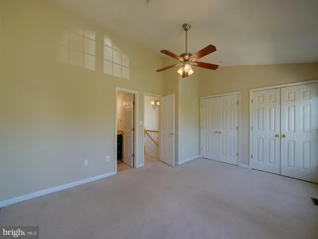 a view of an empty room and a ceiling fan