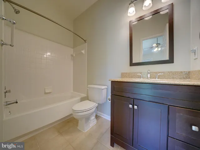 a bathroom with a granite countertop toilet a sink and bathtub