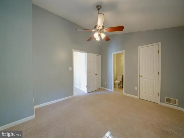 a view of a big room with chandelier fan and closet area