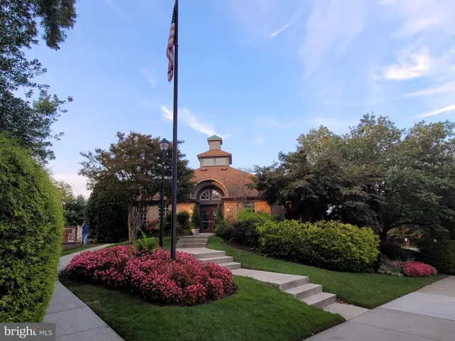 a front view of a house with a yard and fountain