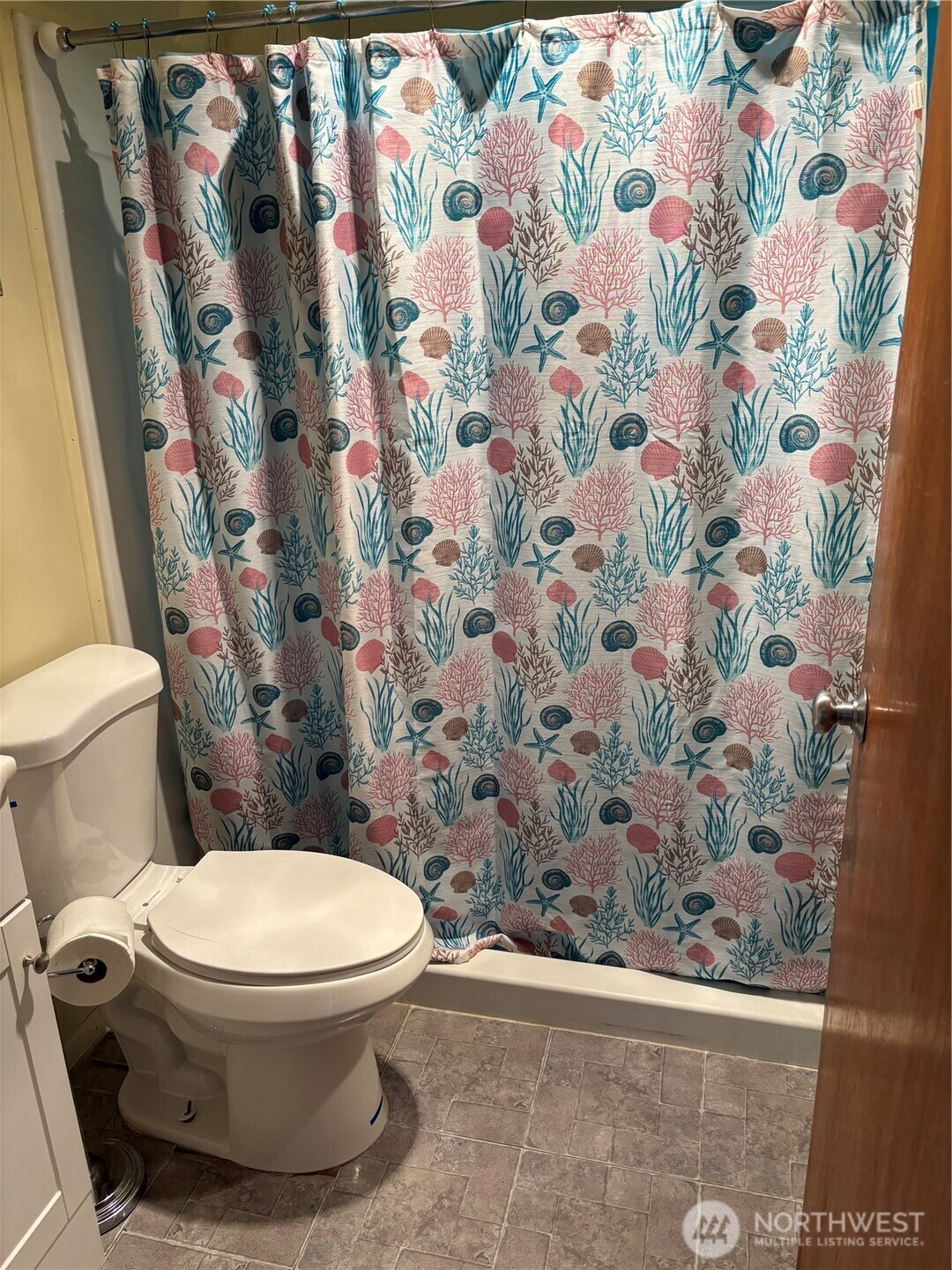 9008 Bong Loop, Unit B Moses Lake, WA 98837 - Photo 12 of 27 a white toilet sitting next to a shower curtain