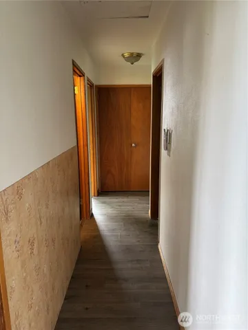 a view of a hallway with wooden floor