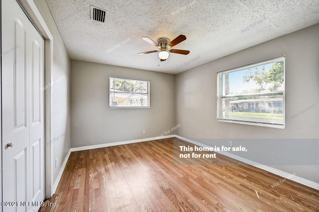 3503 Rogero Road Jacksonville, FL 32277 - Photo 18 of 27 a view of an empty room with window and wooden floor