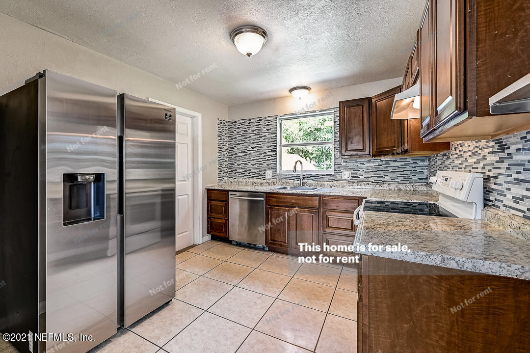 3503 Rogero Road Jacksonville, FL 32277 - Photo 4 of 27 a kitchen with stainless steel appliances granite countertop a sink and a refrigerator