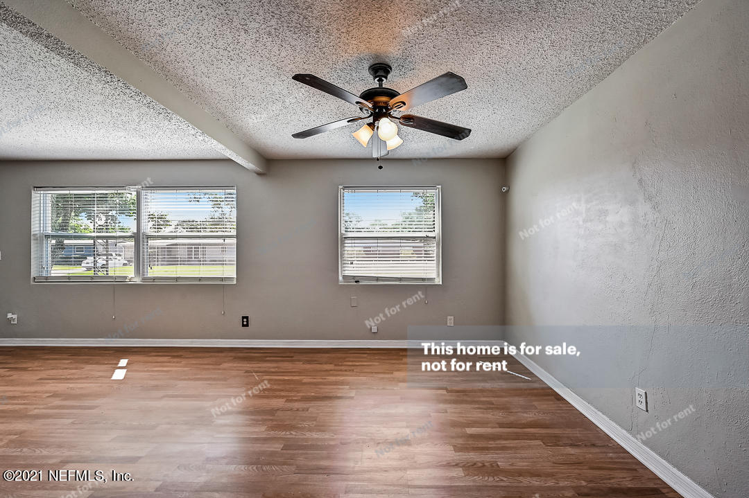 3503 Rogero Road Jacksonville, FL 32277 - Photo 5 of 27 a view of an empty room with window and wooden floor