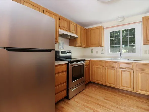 a kitchen with a refrigerator sink and cabinets