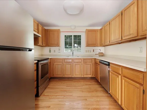 a kitchen with stainless steel appliances granite countertop a sink a stove and a refrigerator