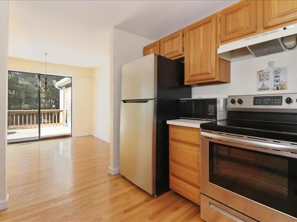 a kitchen with a refrigerator stove and wooden cabinets