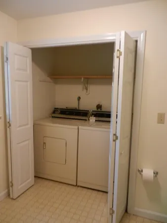 a utility room with cabinets washer and dryer
