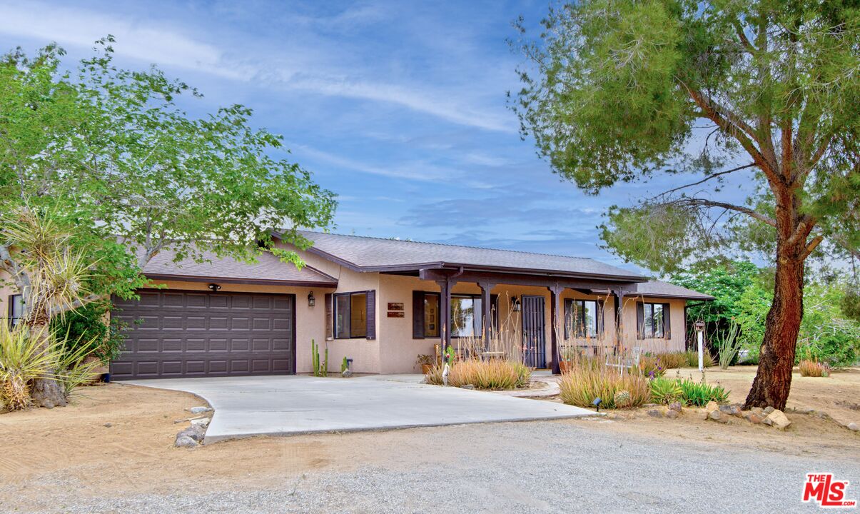 6942 Sunnyhill Road Joshua Tree, CA 92252 - Photo 1 of 2 a front view of a house with garden
