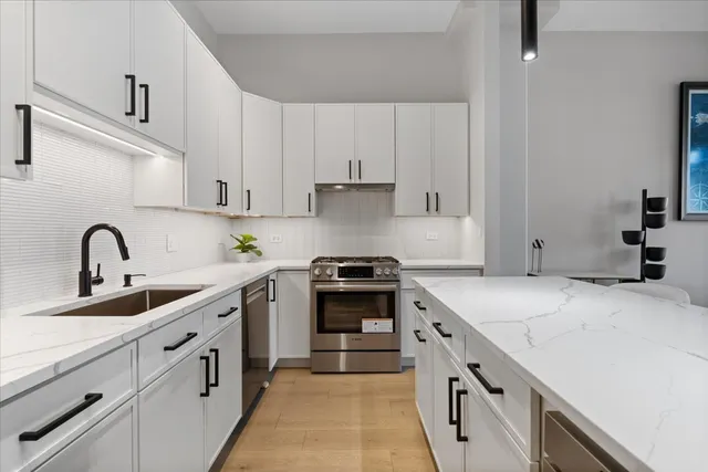 a kitchen with white cabinets and appliances