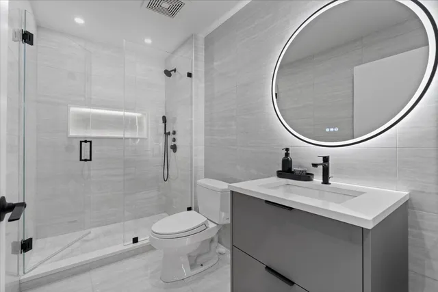 a bathroom with a sink a toilet and shower