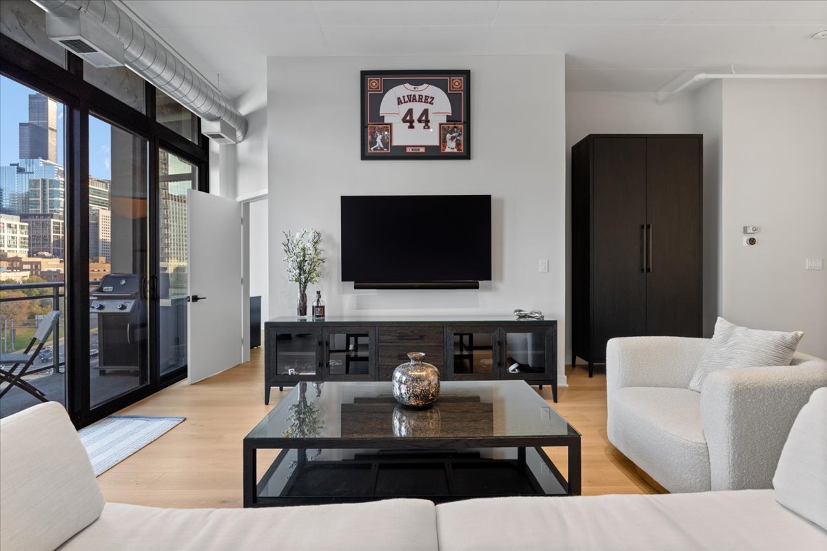 740 West Fulton Street, Unit 507 Chicago, IL 60661 - Photo 6 of 27 a living room with furniture and a flat screen tv