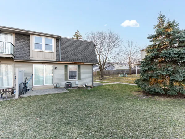 a view of a house with a backyard and a tree
