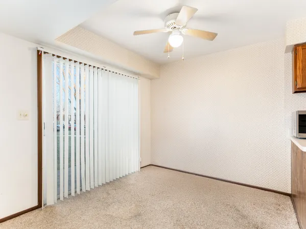 an empty room with a ceiling fan and a window