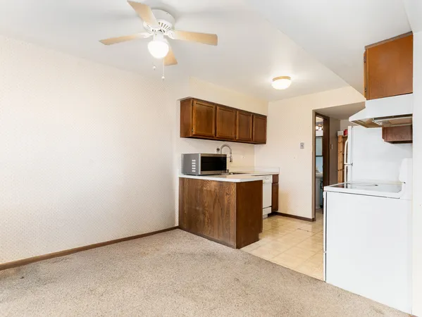 a kitchen with a refrigerator and a stove top oven