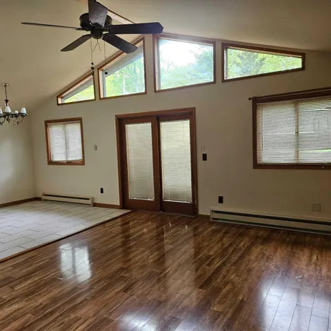 an empty room with wooden floor and windows