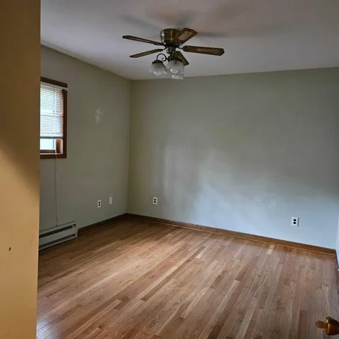 wooden floor in an empty room with a window