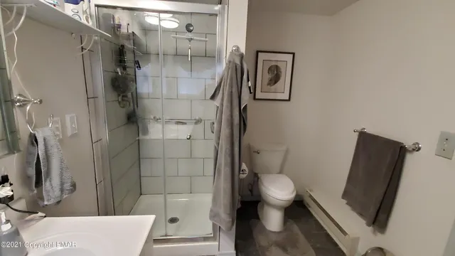 a bathroom with a granite countertop toilet and a shower