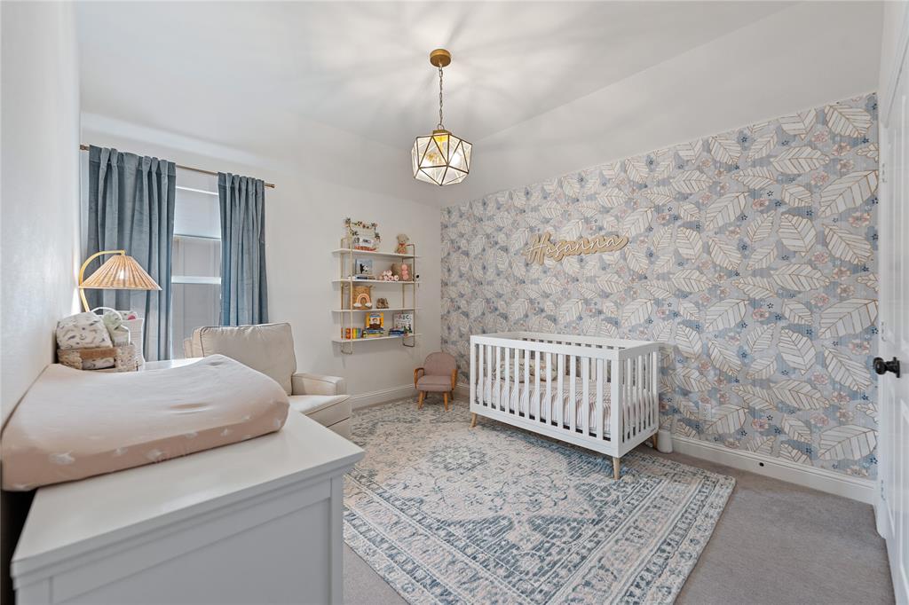 5244 Ranchero Trail Fort Worth, TX 76126 - Photo 28 of 31 Bedroom with a crib, wallpapered walls, and light colored carpet