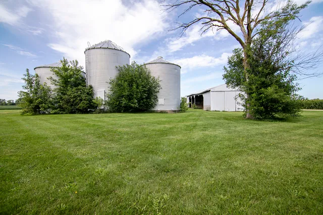 a view of a house with a yard and a large tree